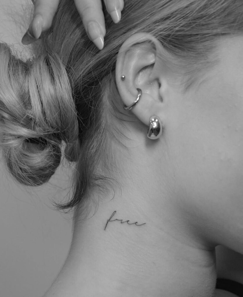 Minimalistyczny tatuaż fine line z napisem „free”, delikatnie umieszczony na boku szyi, za uchem. Subtelny projekt literniczy wykonany czarnym tuszem, o lekkim, odręcznym przepływie, wyrażający wolność, delikatność i osobiste znaczenie w stonowanej formie. Tatuaż wykonany przez Sonyę (@inksefer) w Fineline Tattoo Gallery dla Tattoo Kraków Kolektyw Artystów.